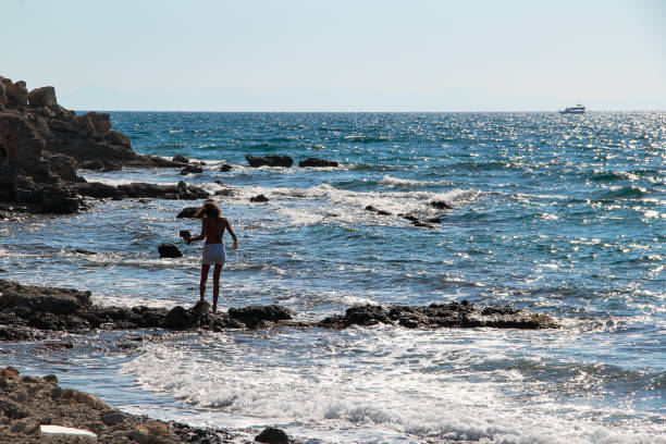 istock Woman alone at the rocky beach 1182948412