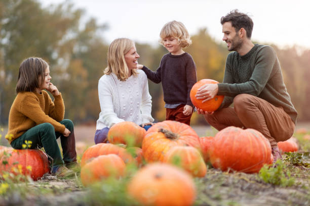 istock Happy young family in pumpkin patch field 1182948467