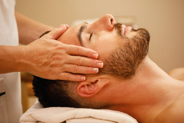 スパセンターでのヘッドマッサージ中のリラックスした男性のクローズアップ。 - facial massage ストックフォトと画像