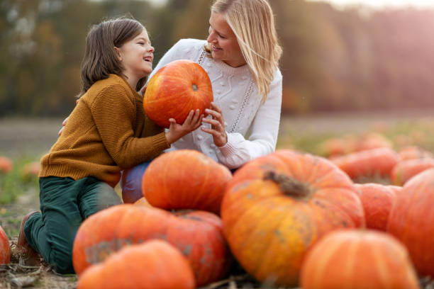 istock Mother and son in pumpkin patch field 1182948556