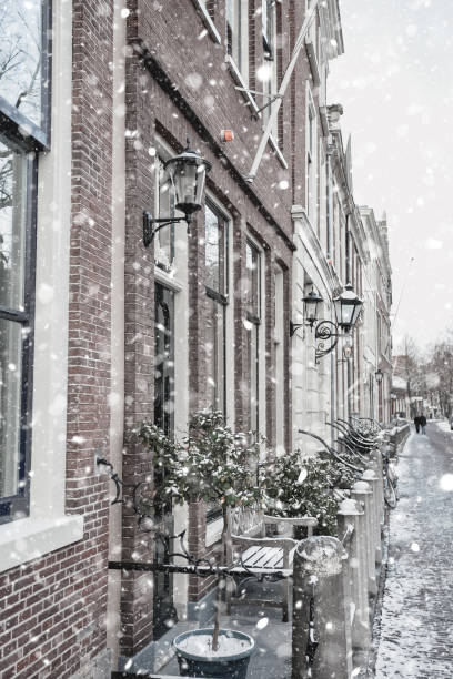 Delft residential district Delft Netherlands Houses in residential district view at winter snowstorm. Pastel trendy toning. Beautiful inspiring moody faded scenery delft winter netherlands snow stock pictures, royalty-free photos & images