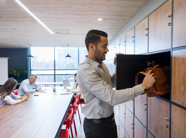 Entrepreneur at a co-working space putting his briefcase in a locker