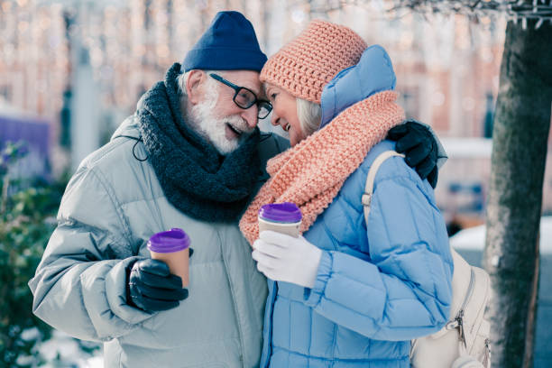 istock Cute senior couple hugging under the tree in winter day 1182953105