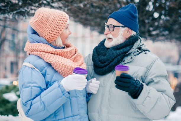istock Aged man and woman drinking coffee to go outdoors in winter 1182955111