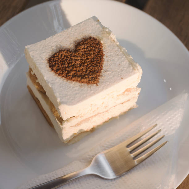 Tiramisu cake dessert with caffee taste on white plate with fork.