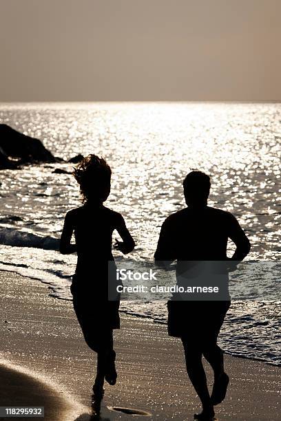 Два Человека Бег На Пляже На Рассвете Сепия Цвета — стоковые фотографии и другие картинки Активный образ жизни