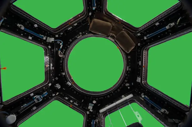 Photo of Porthole of space station isolated on green background. Elements of this image furnished by NASA.