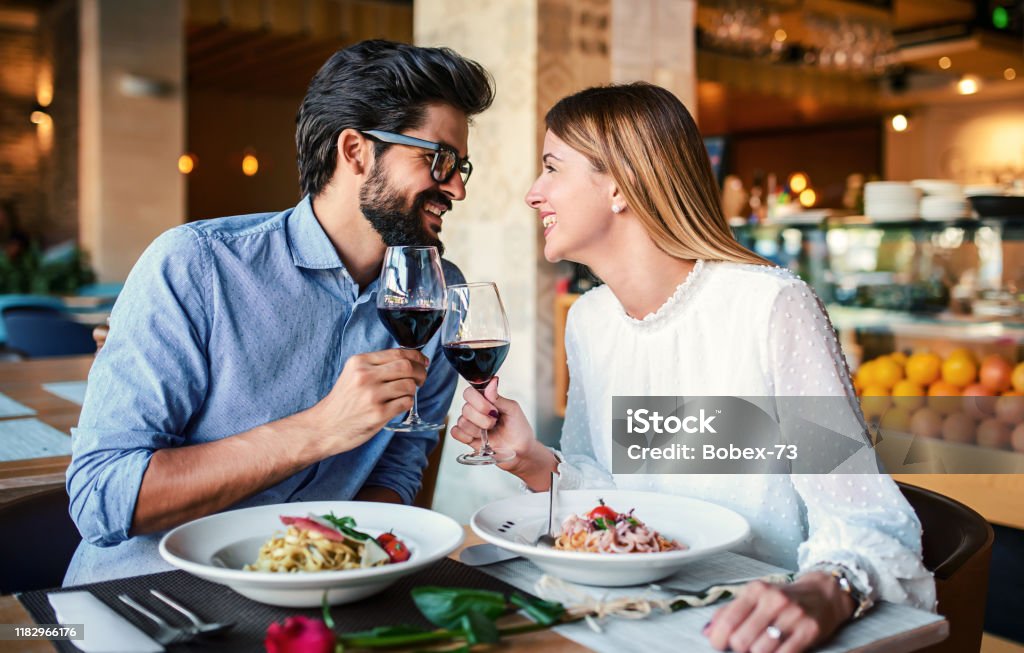 Paste and red wine. Young couple enjoying lunch in the restaurant. Lifestyle, love, relationships, food concept Romantic couple enjoying lunch in the restaurant, eating paste and drinking red wine. Lifestyle, love, relationships, food concept Restaurant Stock Photo