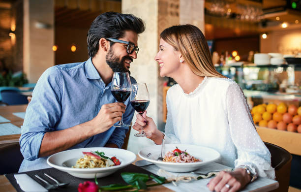 Paste and red wine. Young couple enjoying lunch in the restaurant. Lifestyle, love, relationships, food concept stock photo