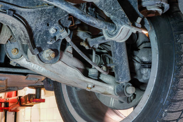 détail de roue de voiture et de suspension de l'automobile soulevée à la station-service de réparation - arms lifted photos et images de collection