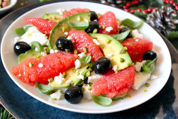 Salad with avocado, grapefruits, feta cheese, black olives and pistachio for Christmas. stock photo