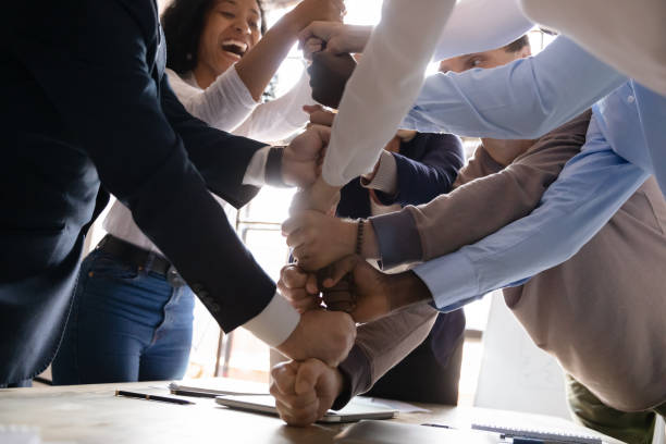 istock Overjoyed multiracial business team stack fists together, close up view 1182967289