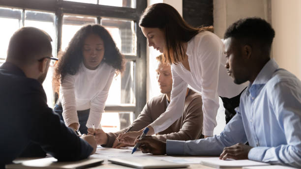 istock Focused diverse team people discuss corporate paperwork share ideas 1182967300