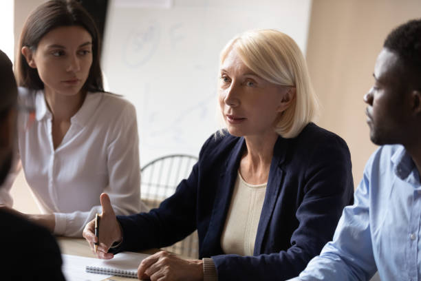 istock Older female mentor teacher conduct corporate briefing teaching diverse interns 1182967346