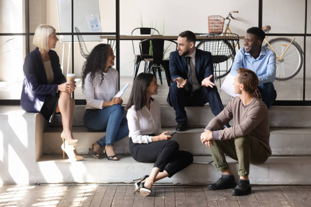 istock Happy multiracial business people communicating sit on modern office floor 1182967347