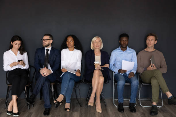 istock Serious stressed diverse businesspeople sit on chairs waiting job interview 1182967348