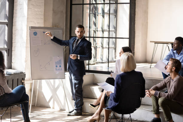 istock Serious male speaker give business presentation drawing on flip chart 1182967360