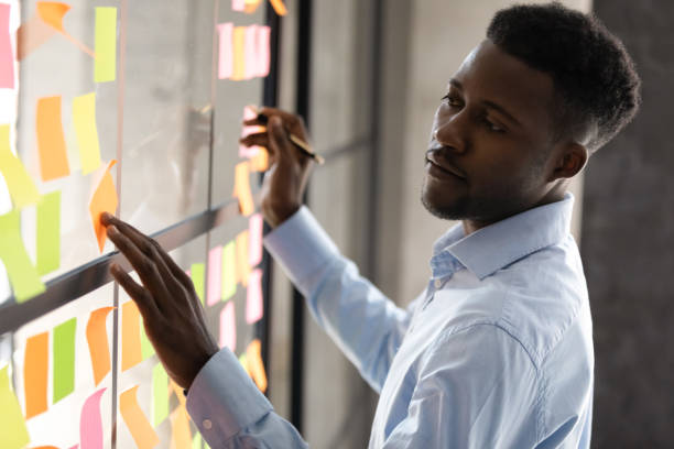 istock Serious african american businessmen managing project tasks on sticky notes 1182967379