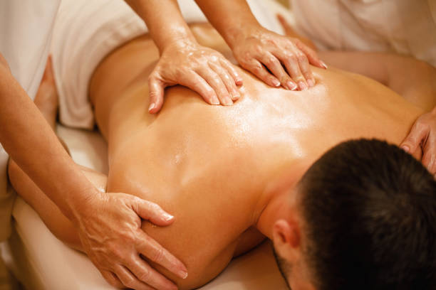 istock Close-up of four hands back massage. 1182967581