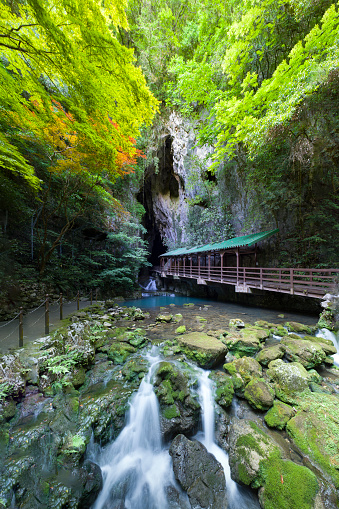 Puente de entrada sobre agua azul a la cueva de Akiyoshido (Yamaguchi), Japón photo