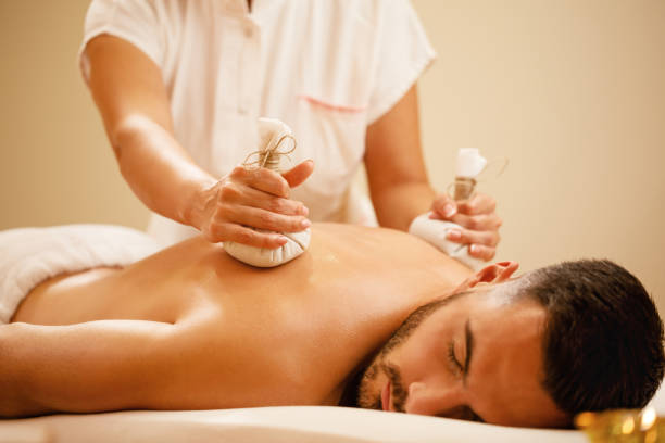 istock Relaxed man receiving Thai herbal compress massage at the spa. 1182968548