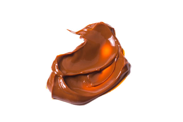 istock Melted tasty caramel splashes isolated on white background. 1182970133