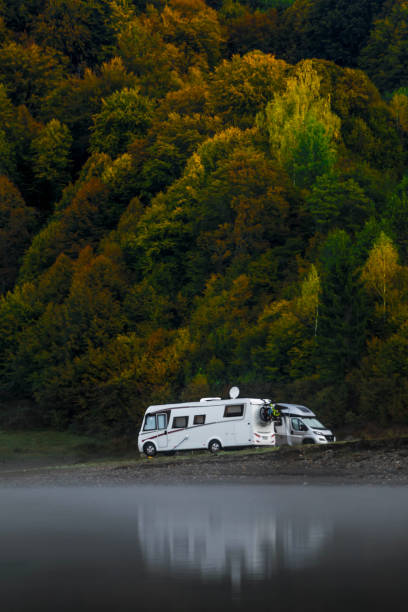 acampamento em um lago com caravanas nas árvores agradáveis do outono do fundo. - semi truck vehicle trailer truck empty - fotografias e filmes do acervo