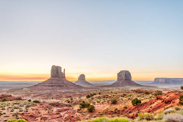 weitwinkelansicht von buttes und horizont im monument valley bei sonnenaufgang buntes licht in arizona mit orangefarbenen felsen - merrick butte stock-fotos und bilder