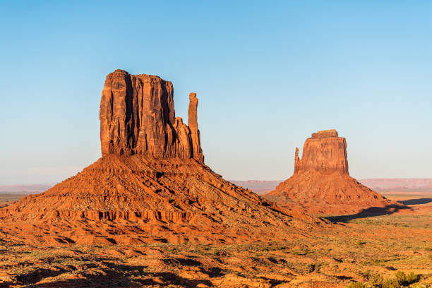 blick auf berühmte mesa butte formationen nahaufnahme mit roter orange rockfarbe am horizont in monument valley canyons bei sonnenuntergang in arizona - 16747 stock-fotos und bilder