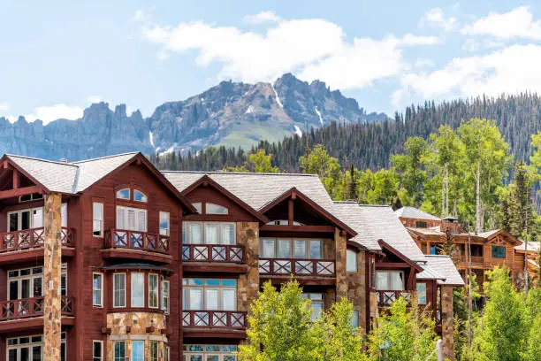 Photo of Telluride, Colorado small town Mountain Village in summer 2019 with view of San Juan Mountains and modern resort lodge apartment condo architecture