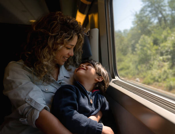 istock Loving mother and son riding on the train 1182972100