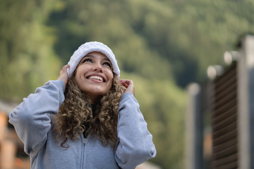 Happy woman enjoying the winter outdoors and wearing a hat - lifestyle concepts