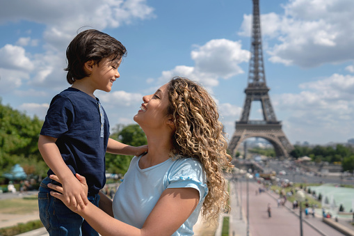 Having fun time near the world famous landmark in Paris. Portrait of smiling mother and daughter travellers standing in Paris, France