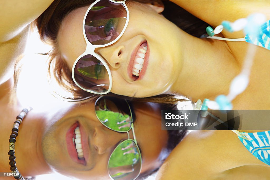 close-up of young interracial couple huddling together on summers day  Fashionable Stock Photo