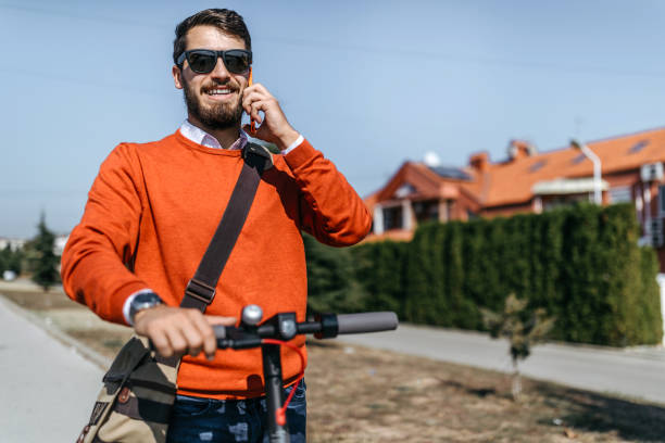 istock Man with electric scooter talking on mobile phone 1182979227