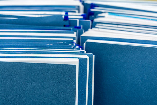 istock Two row of blue folders with documents in paper box, close-up paperwork abstract background 1182981751