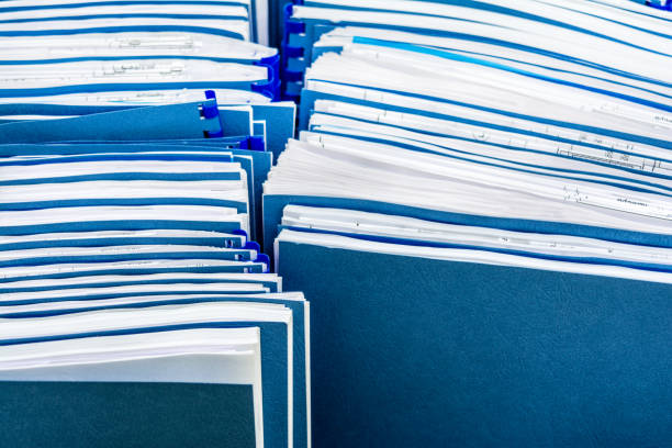 istock Two row of blue folders with documents in paper box, close-up paperwork abstract background 1182981823