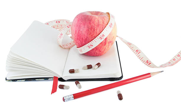 istock Diary with apple and pills for effective dieting 118298221
