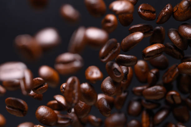 istock black coffee grains while cooking. Iced in the air on a black background for design 1182994539