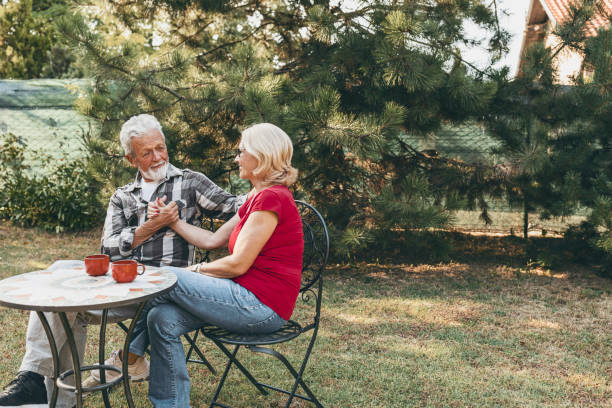 istock Senior couple sitting in backyard drinking coffee 1182995999