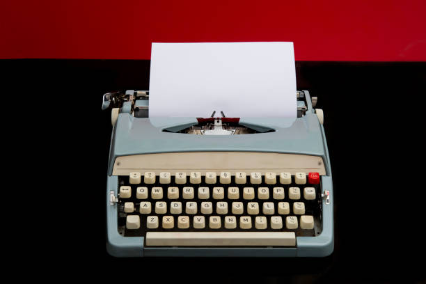 istock Manual typewriter with blank white paper on red and black background 1182999626
