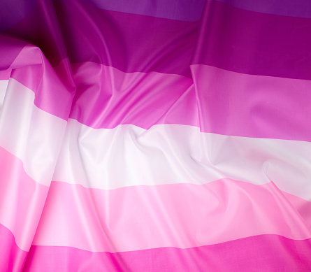 textile pink flag of lesbians, concept of the fight for equal rights and against sexual discrimination, surface waves, full frame