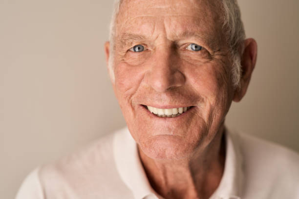 istock Content senior man smiling while sitting alone at home 1183000682
