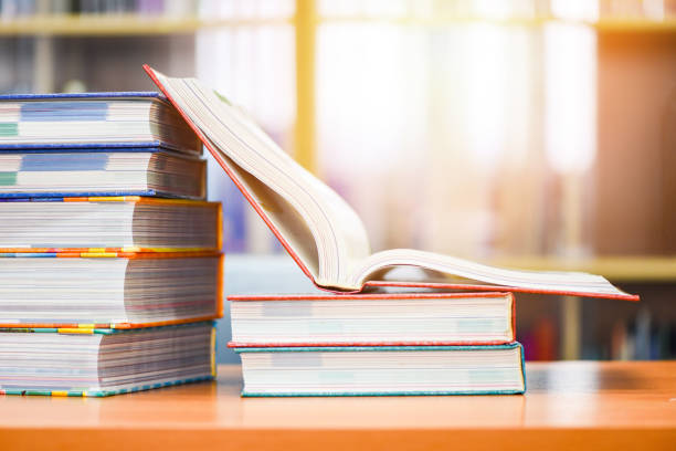 Education concept back to school and business study - open book in library with book stacked on the table Education concept back to school and business study / open book in library with book stacked on the table textbook stock pictures, royalty-free photos & images