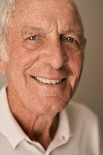 istock Senior man smiling contently while sitting alone at home 1183000844