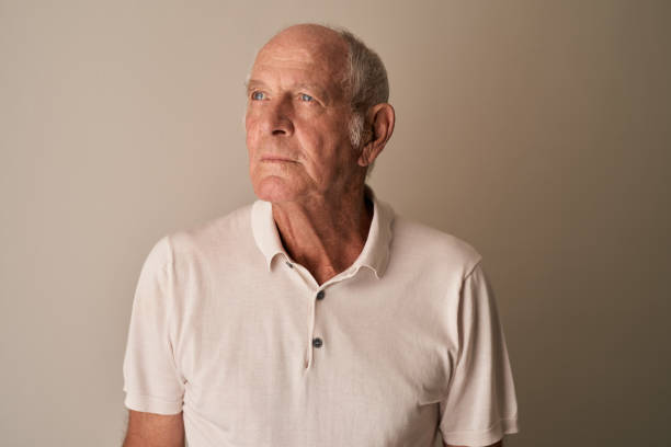 Sad senior man sitting alone in his room