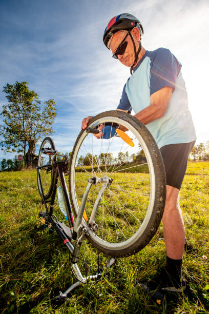 istock Senior Man Cycler Repairing His Flat Tire 1183001088