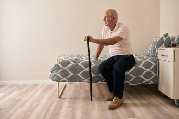 istock Sad senior man with a cane sitting on his bed 1183001841