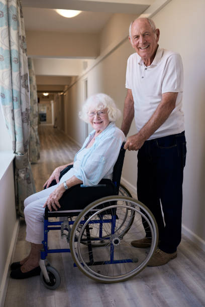 istock Smiling senior couple together in a retirement home hallway 1183006802