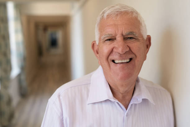 istock Laughing senior man standing in a retirement home hallway 1183007152